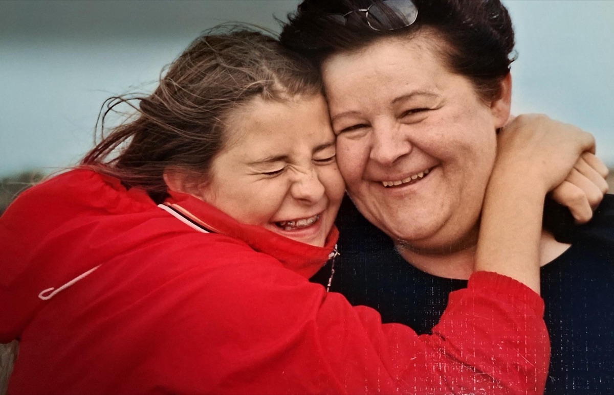 Mama und Tochter lachen und halten sich im Arm